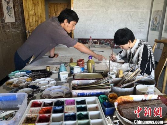 圖為2020年8月下旬，敦煌“80后”畫(huà)家張杰龍(左)在為云南麗江“學(xué)生”莫北講解敦煌壁畫(huà)的繪畫(huà)技巧?！●T志軍 攝