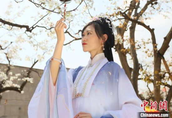 圖為蘭州青年身穿漢服在百年梨園賞景?！「哒?攝