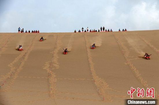 6月13日，敦煌鳴沙山月牙泉景區(qū)舉辦滑沙比賽。　張曉亮 攝