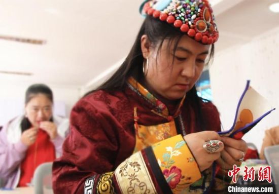 圖為裕固族婦女學(xué)習(xí)刺繡?！∈缝o靜 攝
