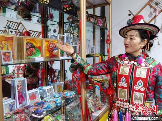 圖為身著民族服飾的隴原巧手展示手工藝品。(資料圖) 徐雪 攝
