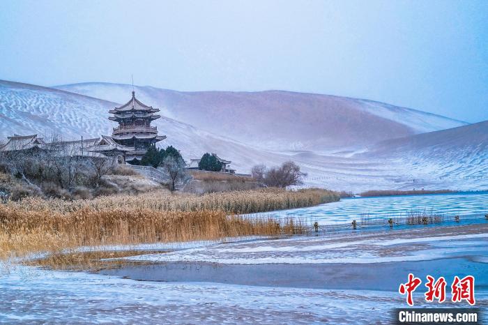 2021年11月28日，雪落鳴沙山月牙泉景區(qū)。　王斌銀 攝