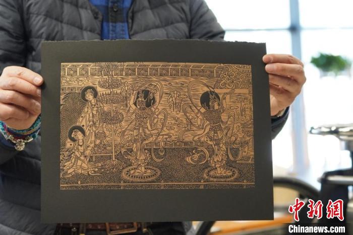圖為手工書藝人展示敦煌雕版壁畫印刷品?！【琶赖┰?　攝