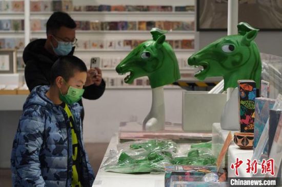 圖為“神馬來了”銅奔馬頭套吸引參觀者駐足?！【琶赖┰?攝