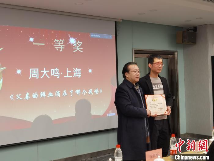 圖為作家、西北師范大學新聞與傳媒學院院長徐兆壽頒發(fā)一等獎證書，代領獎者上臺領獎?！钅?攝