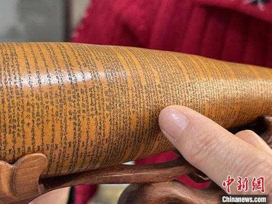 圖為長約二十公分的長條葫蘆雕刻佛教經(jīng)文作品?！堟?攝