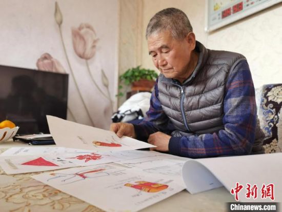圖為陸鵬飛向記者展示多年帶隊(duì)的手寫筆記?！堟?攝