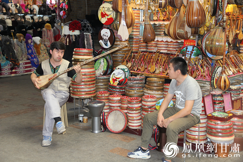 烏魯木齊二道橋巴扎內(nèi)，店主正在向客人展示樂(lè)器。楊文遠(yuǎn) 攝