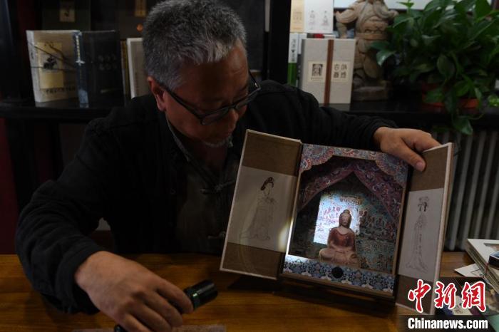 圖為讀者出版集團讀者晉林工作室獨立出品人徐晉林，展示互動性強的敦煌題材手工書。(資料圖) 楊艷敏 攝