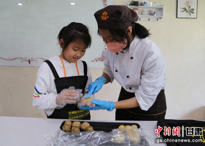 圖為在甘臺胞小朋友在工作人員指導下制作月餅。九美旦增 攝