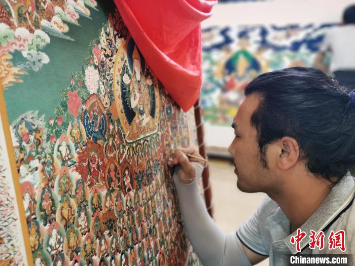 圖為更登才讓的徒弟繪畫唐卡。　張?zhí)砀?攝