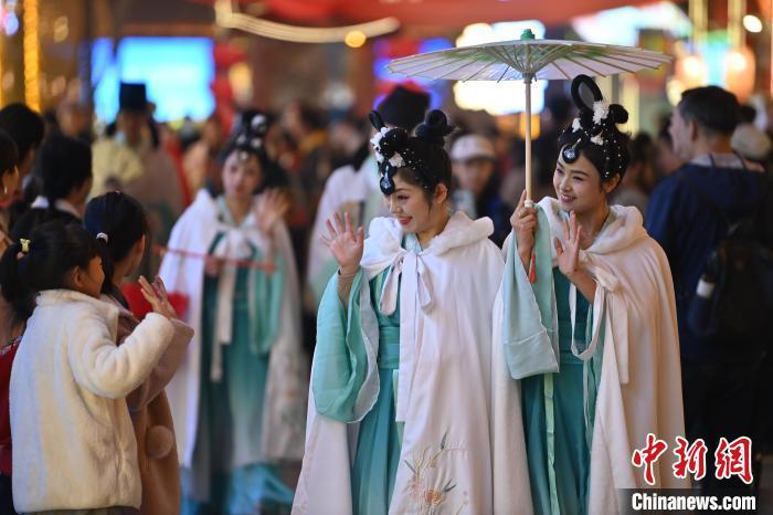 圖為街區(qū)人員著傳統(tǒng)服飾與游人互動(dòng)。李亞龍 攝</p><p>
