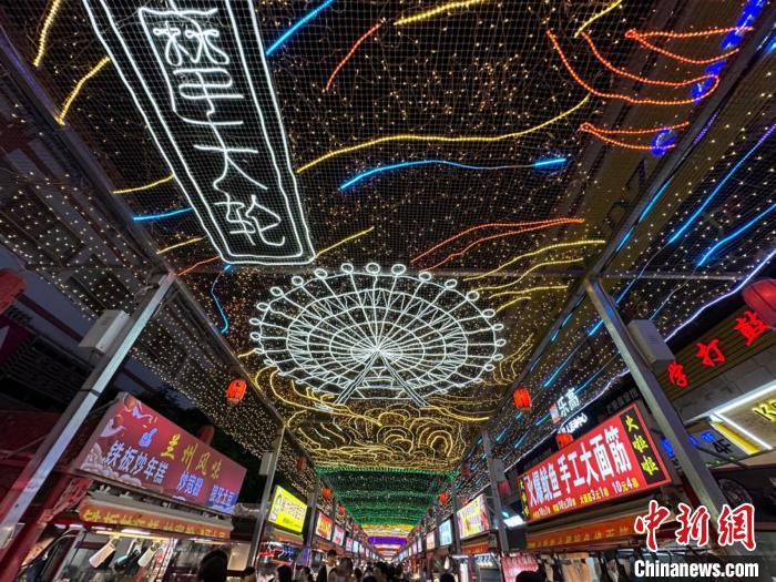 圖為明清街夜市燈光點(diǎn)亮具有武威文化元素的“摩天輪”彩燈。　戴文昌 攝</p><p>