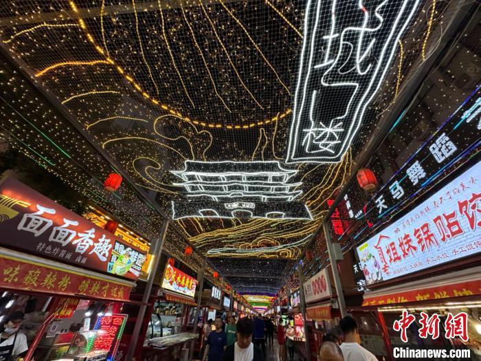 圖為明清街夜市燈光點(diǎn)亮具有武威文化元素的“涼州古城門”彩燈。　戴文昌 攝</p><p>
