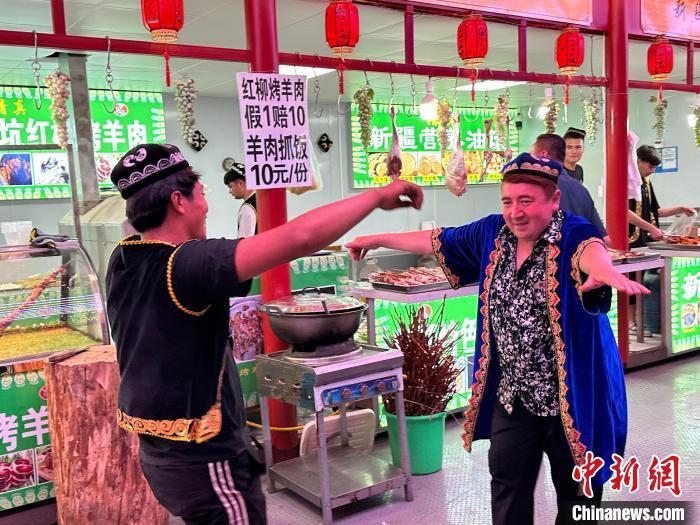 圖為餐飲經(jīng)營者在“西涼不夜城”跳起舞蹈引客。　戴文昌 攝</p><p>