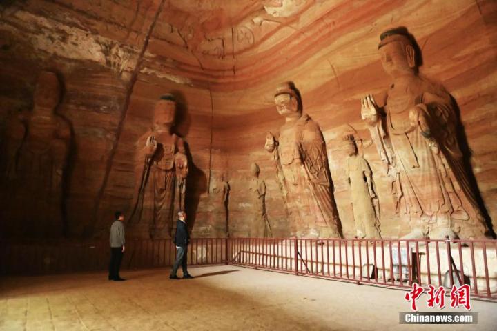 7月15日，游人參觀甘肅省平?jīng)鍪袥艽h百里石窟長廊中的南石窟寺1號窟。百里石窟長廊位于涇川縣境內(nèi)，由512個石窟、5眼窟中石井組成，現(xiàn)存王母宮石窟、鳳凰山石窟、南石窟寺、丈八寺石窟、羅漢洞石窟、太山寺石窟等規(guī)模較大的石窟群，還有數(shù)量眾多的小石窟群。南石窟寺開鑿于北魏永平三年，其中1號窟屬于大型七佛窟，七佛高達6米。中新社記者 李亞龍 攝